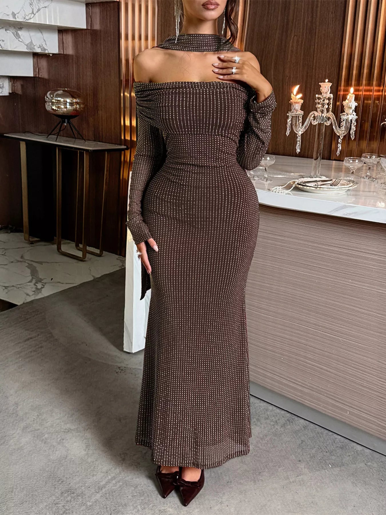 Woman wearing a brown off-shoulder dress in an elegant indoor setting.
