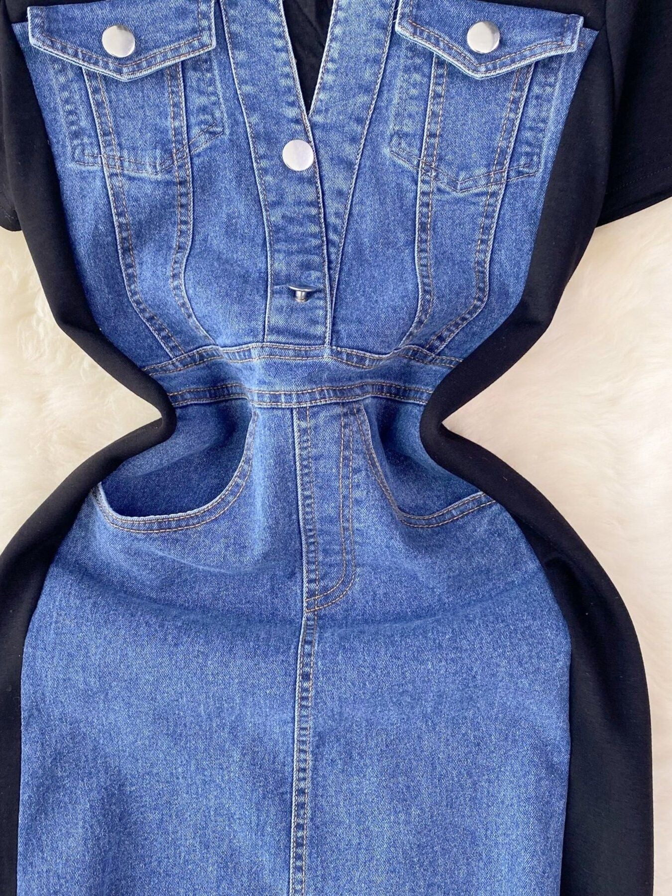 Blue denim dress with black accents on a beige background