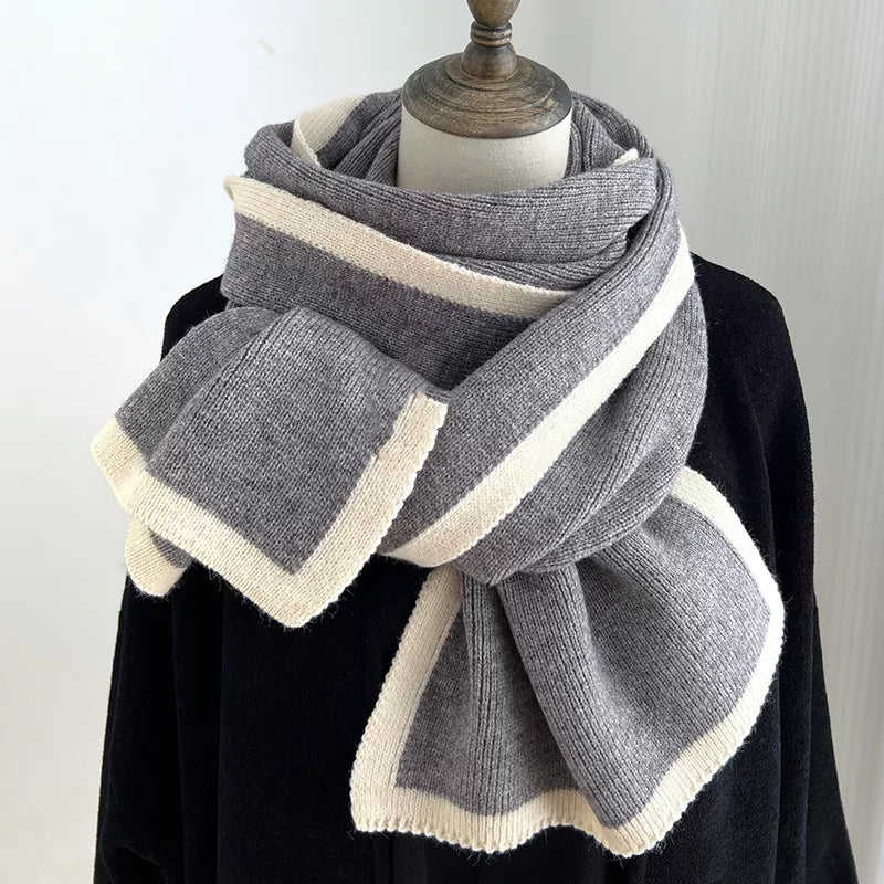 Gray and white striped scarf on a mannequin against a plain background