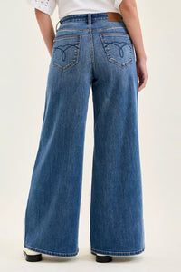 Person wearing blue wide-leg jeans on a white background