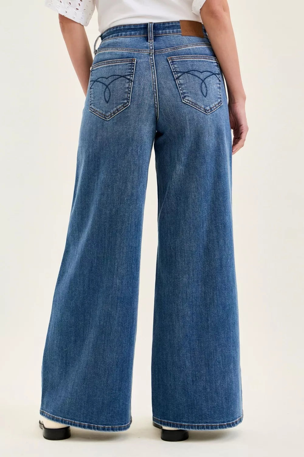 Person wearing blue wide-leg jeans on a white background