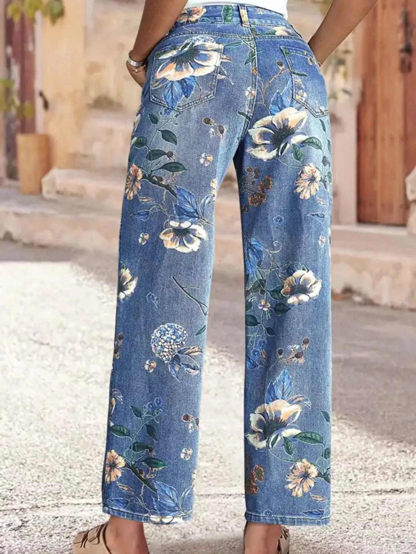 Floral-patterned blue jeans worn by a person on a street.