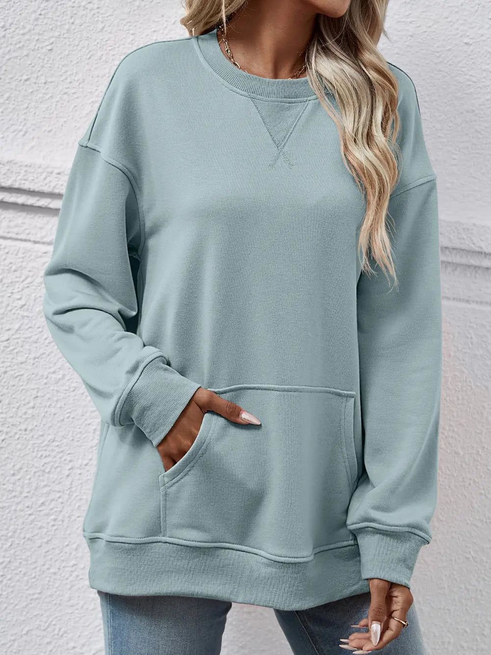 Light blue sweatshirt worn by a person against a light gray background