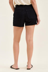 Person wearing black shorts on a plain background