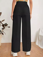 Person wearing black wide-leg pants with a white background