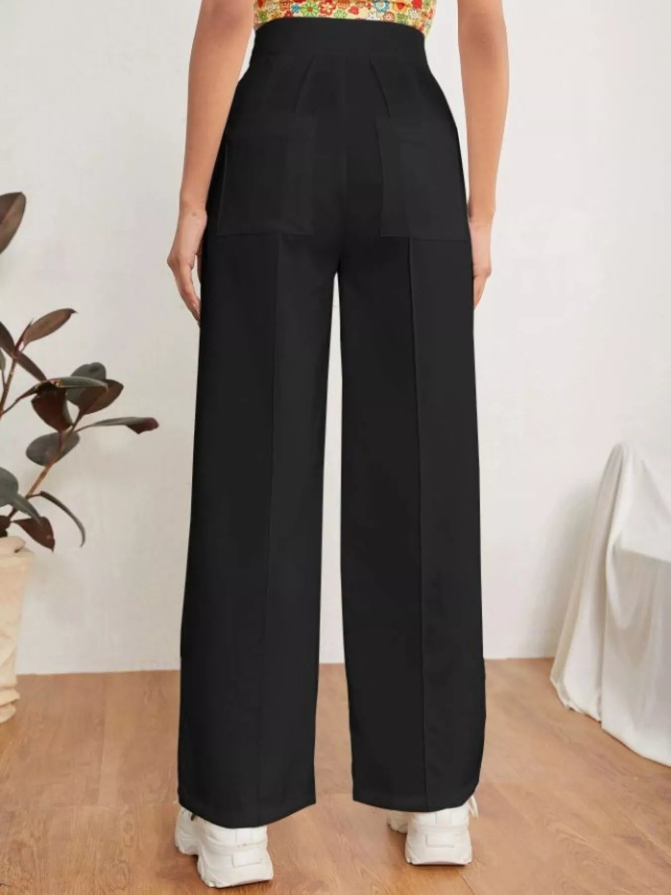 Person wearing black wide-leg pants with a white background