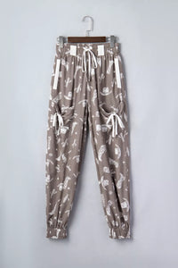 Patterned pants on a hanger against a plain background