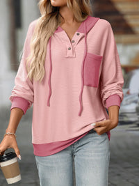 Woman wearing a pink hoodie with a blurred background