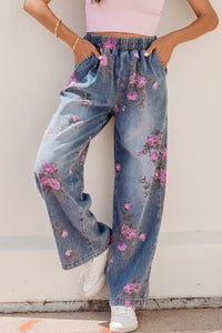 Person wearing floral denim pants with a plain background