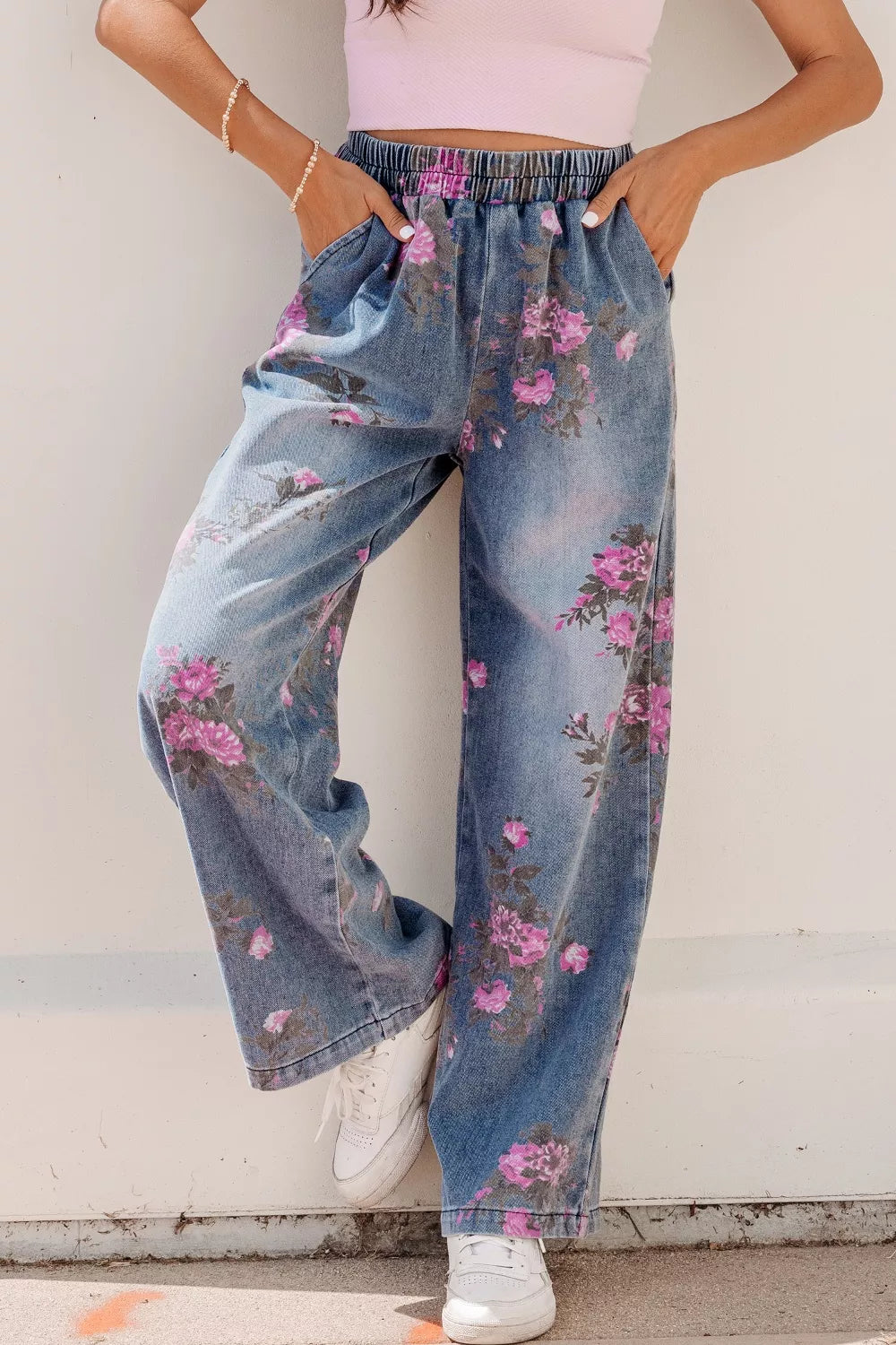 Person wearing floral denim pants with a plain background