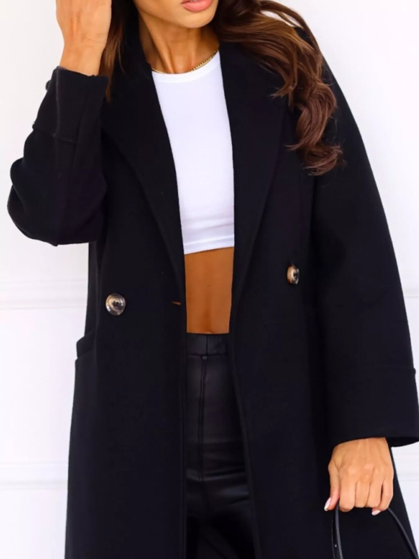 Person wearing a black coat with a white background