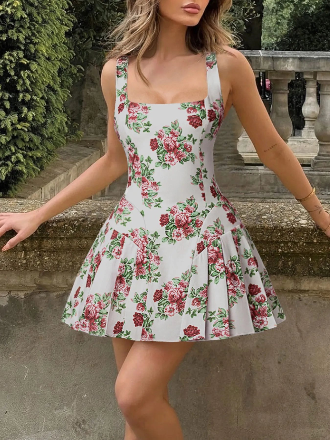 Woman wearing a floral dress standing outdoors with greenery in the background