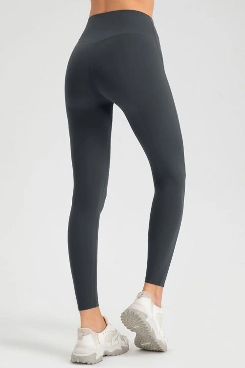 Dark gray leggings worn by a person on a white background