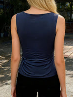 Person wearing a navy blue sleeveless top outdoors