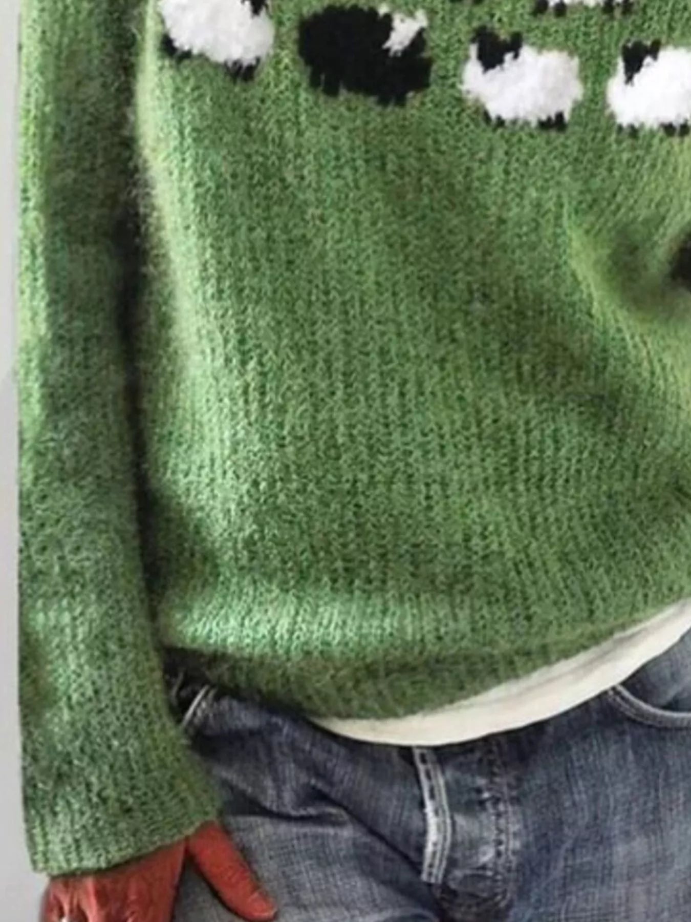 Green sweater with sheep pattern worn by a person