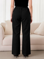 Person wearing black pants standing in a room with a beige sofa.