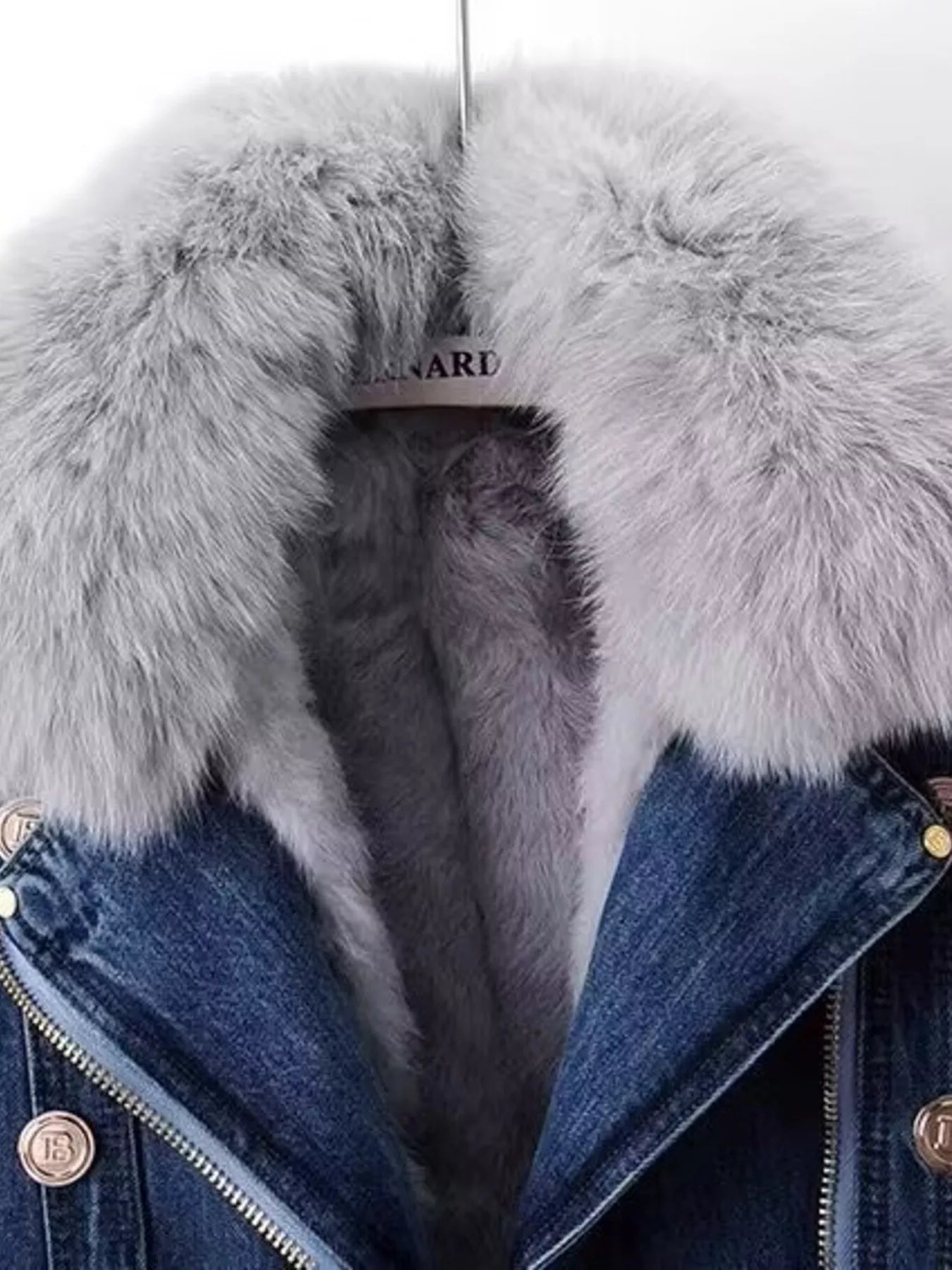 Denim jacket with a fur-lined hood and visible brand name.