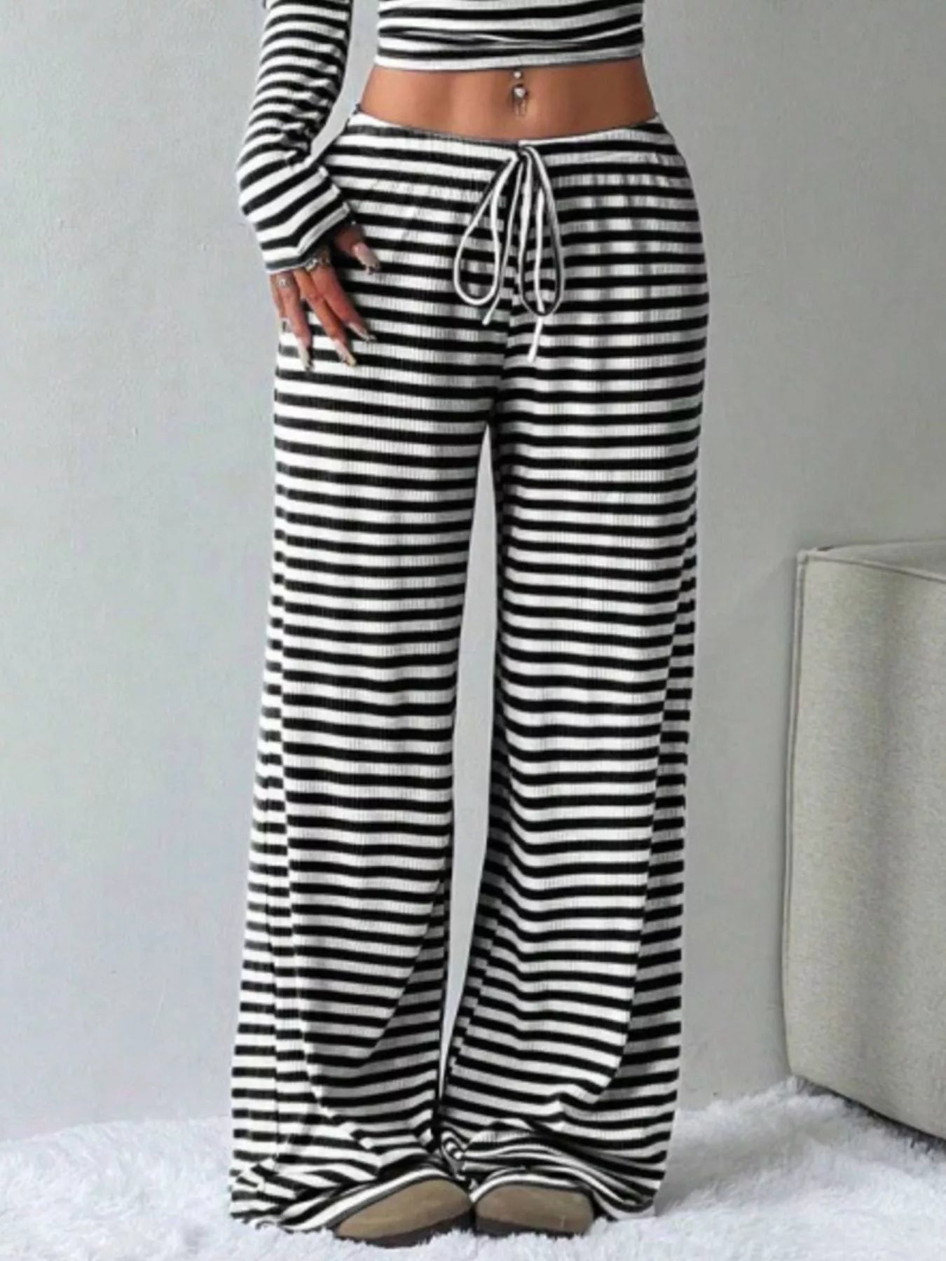 Black and white striped pants with a matching top on a plain background