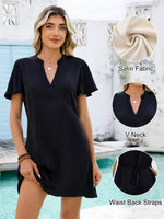 Woman wearing a black dress with close-up details of fabric, neckline, and waist straps by a pool.