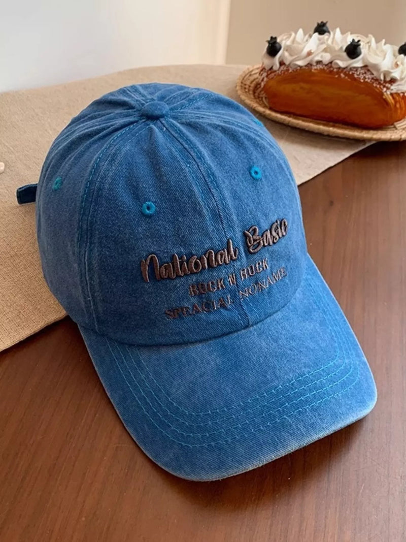 Blue cap with text on a wooden surface with a cake in the background