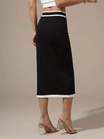 Black skirt with white trim worn by a person on a beige background