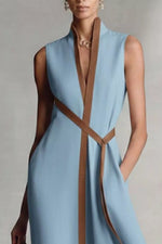Light blue dress with brown straps on a neutral background