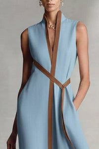 Light blue dress with brown straps on a neutral background