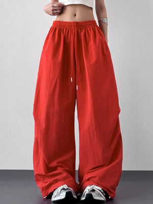 Red wide-leg pants worn by a person on a plain background