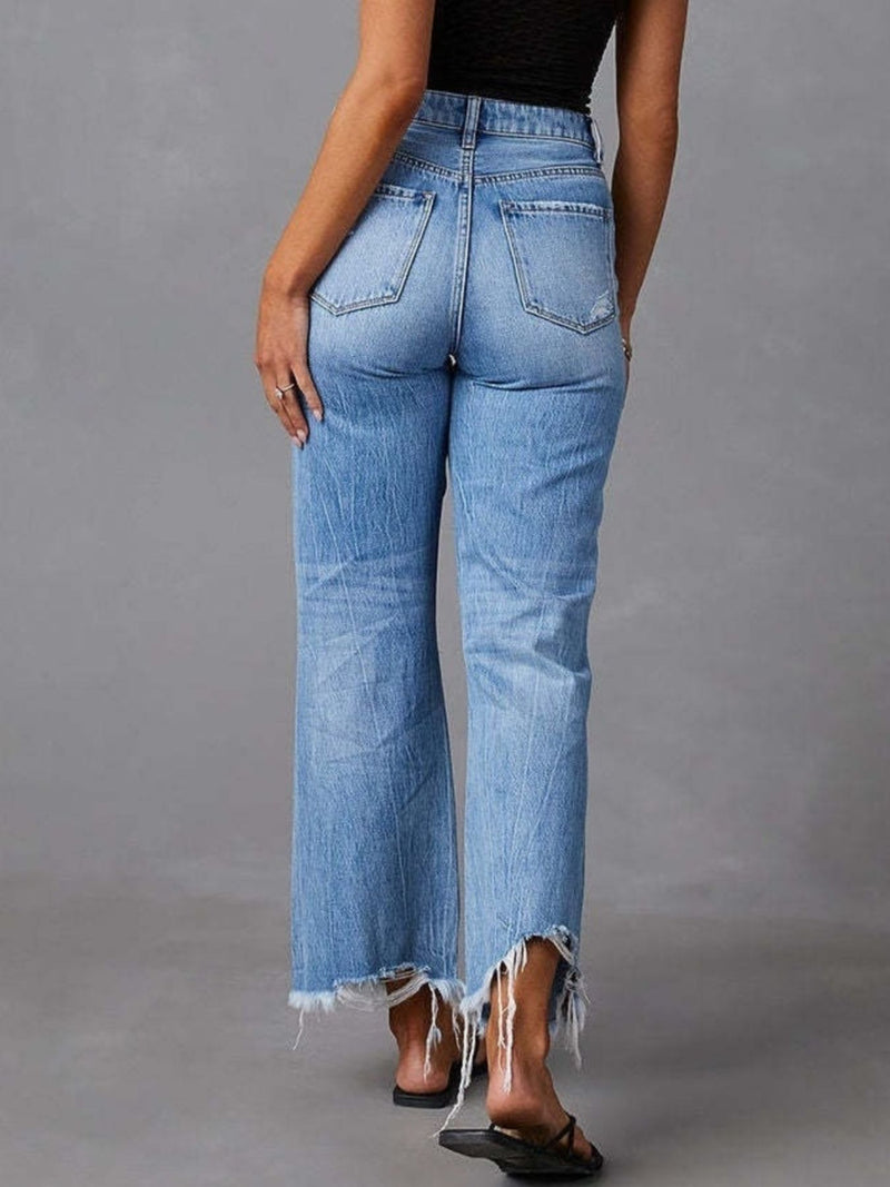 Person wearing blue jeans with a gray background
