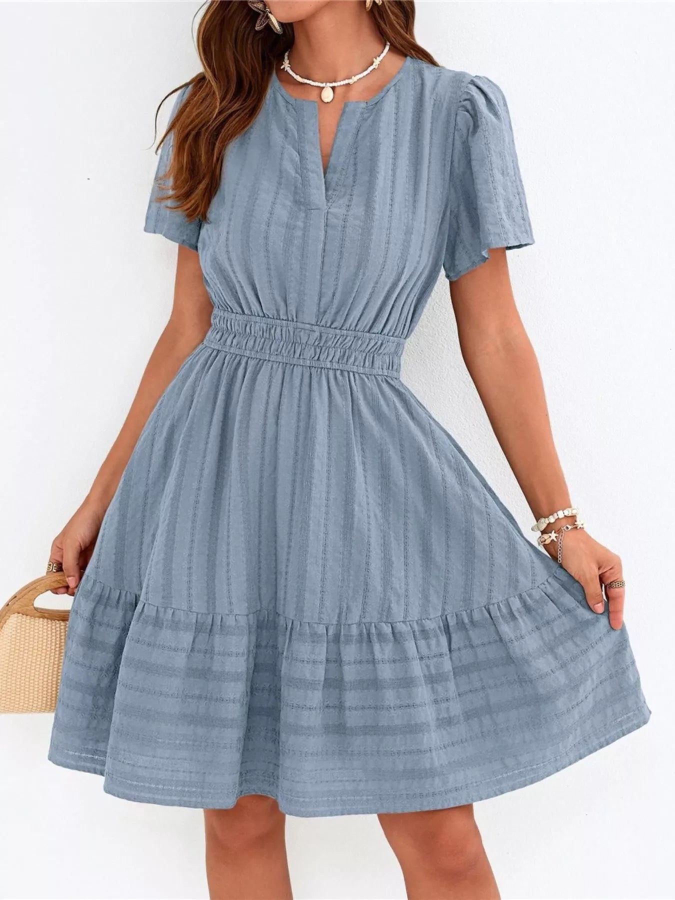 Woman wearing a blue dress with a white background