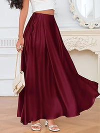 Person wearing a burgundy skirt with a white top in an elegant room.