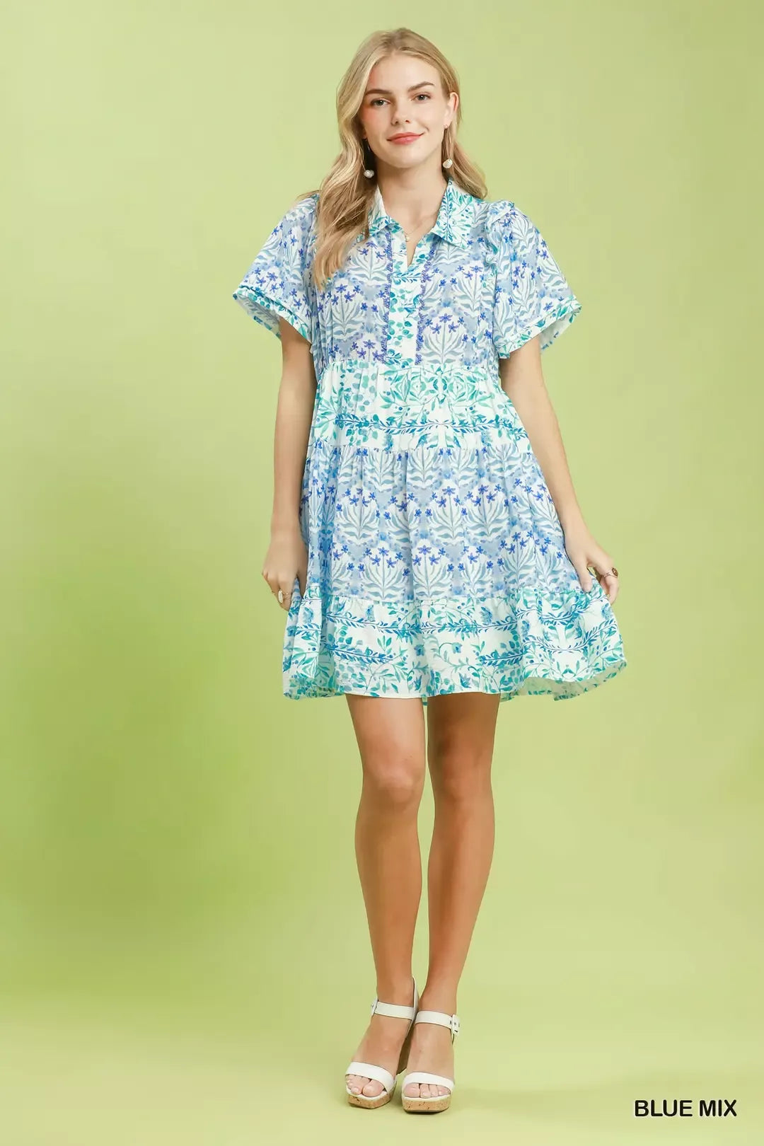 Woman wearing a blue floral dress on a green background