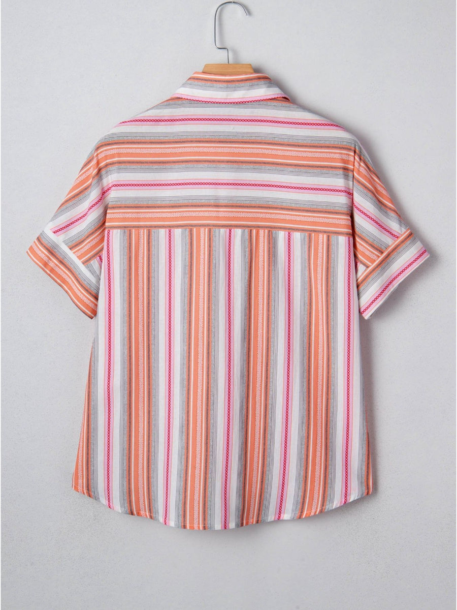 Striped shirt on a hanger against a plain background