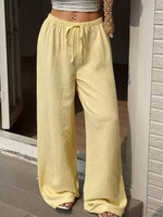 Person wearing yellow wide-leg pants standing on a step.