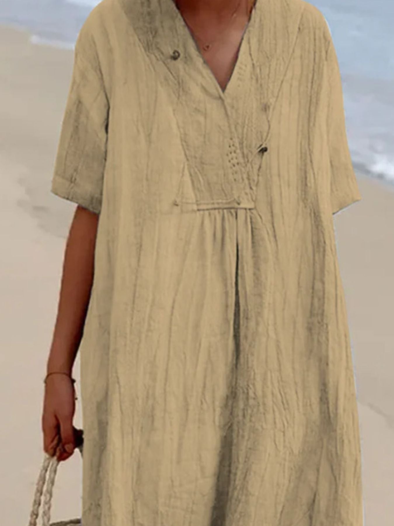 Person wearing a beige dress with a blurred background