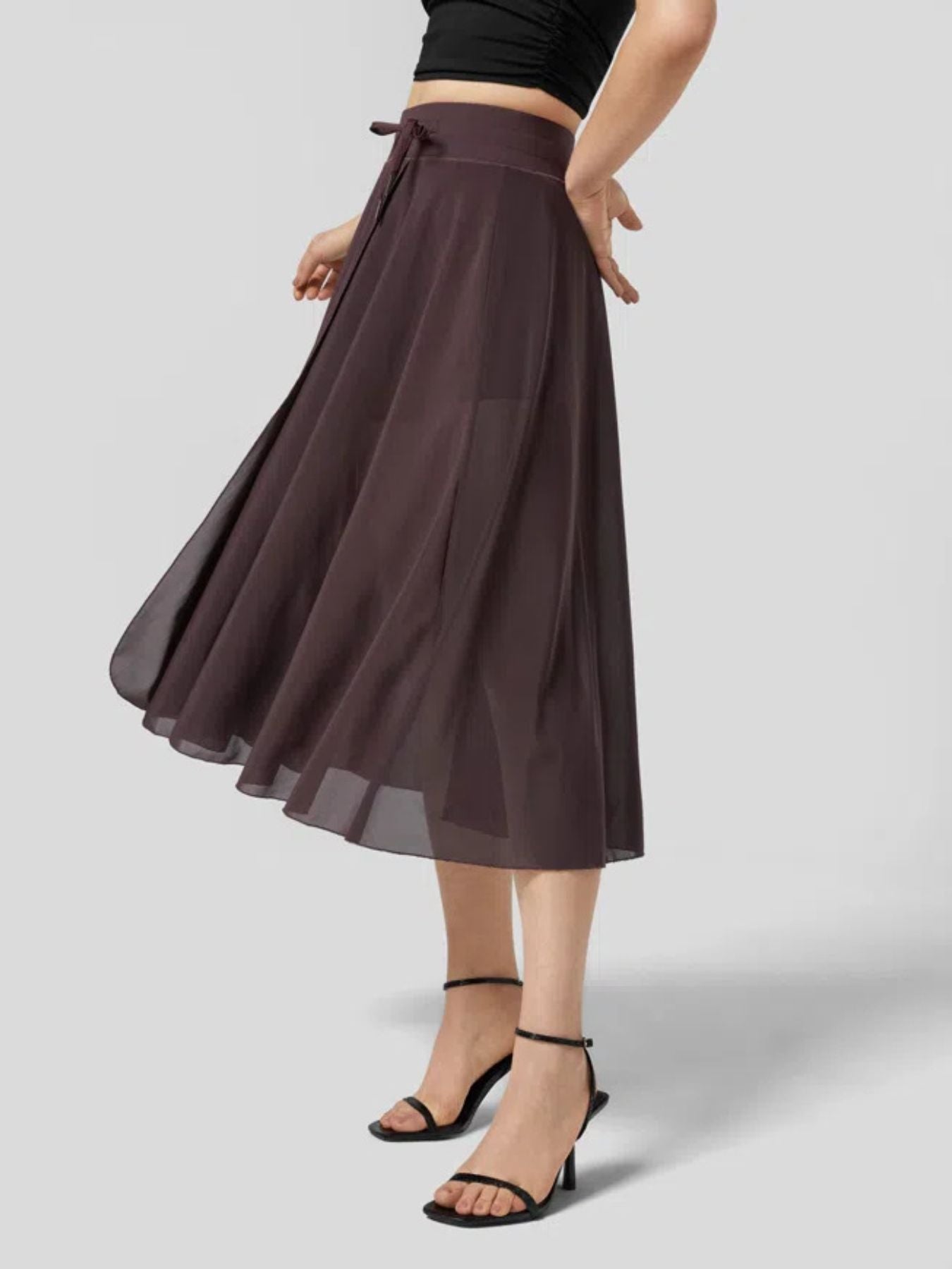 Brown skirt worn by a person on a light gray background