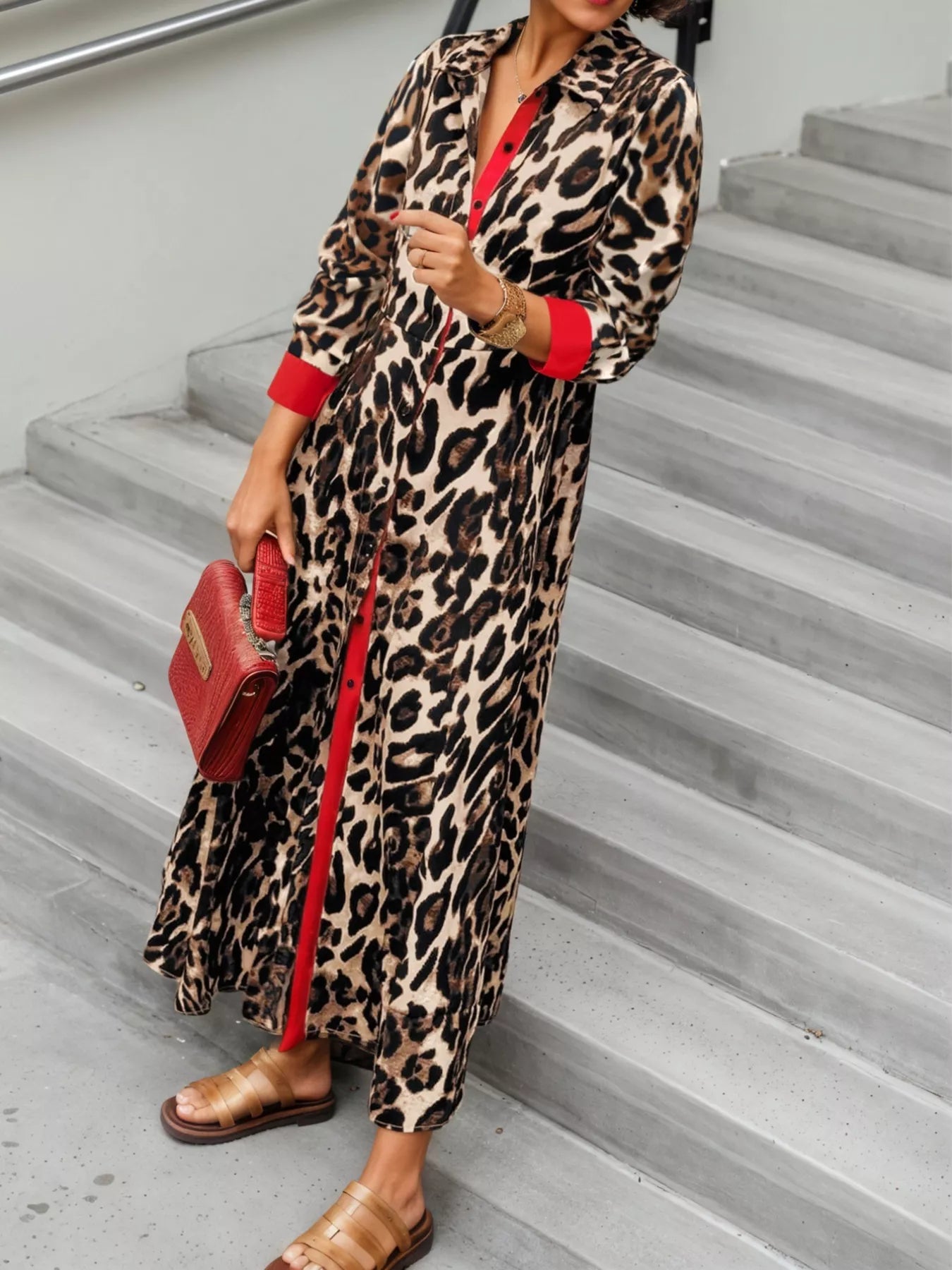 Person wearing a leopard print dress with red accents on a staircase