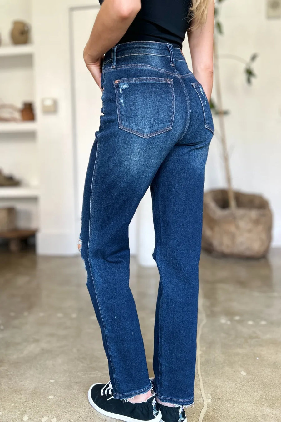 Person wearing blue jeans in a casual setting with a blurred background