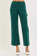 Green pants worn by a person on a white background
