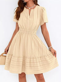 Beige dress worn by a person on a white background