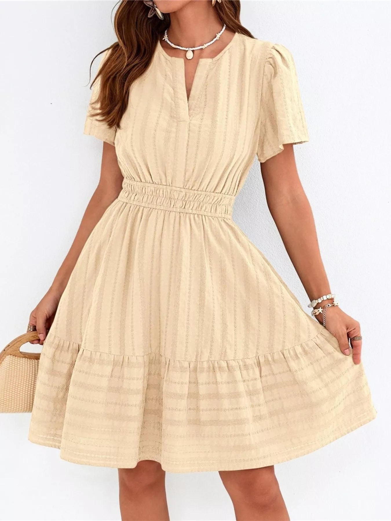 Beige dress worn by a person on a white background
