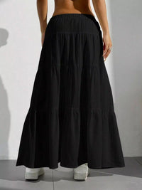 Black tiered skirt worn by a person on a plain background