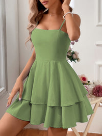 Woman wearing a green dress in an indoor setting with flowers in the background