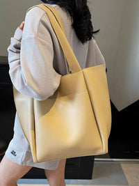 Person holding a yellow tote bag in an indoor setting