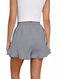 Gray ruffled shorts worn by a person on a white background