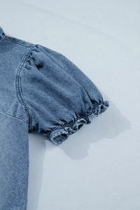 Blue denim top with ruffled sleeves on a light gray background