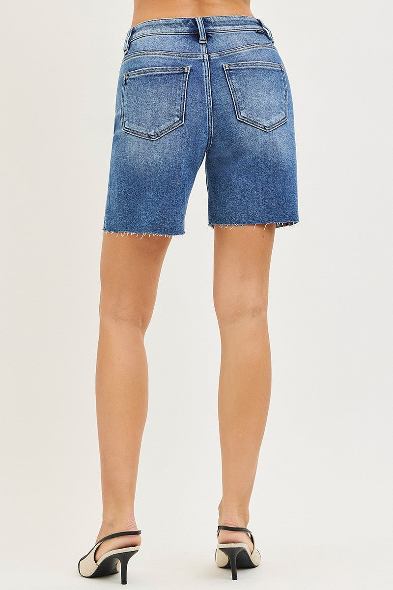 Blue denim shorts worn by a person on a white background