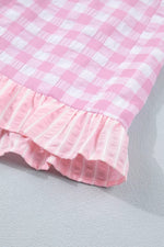 Close-up of a pink and white checkered fabric with ruffled edge on a light gray background
