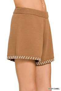 Brown knit skirt with white trim on a white background