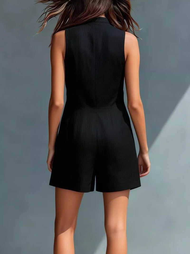 Person wearing a black sleeveless jumpsuit against a gray background